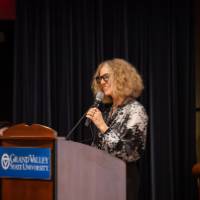 Provost  on stage behind podium